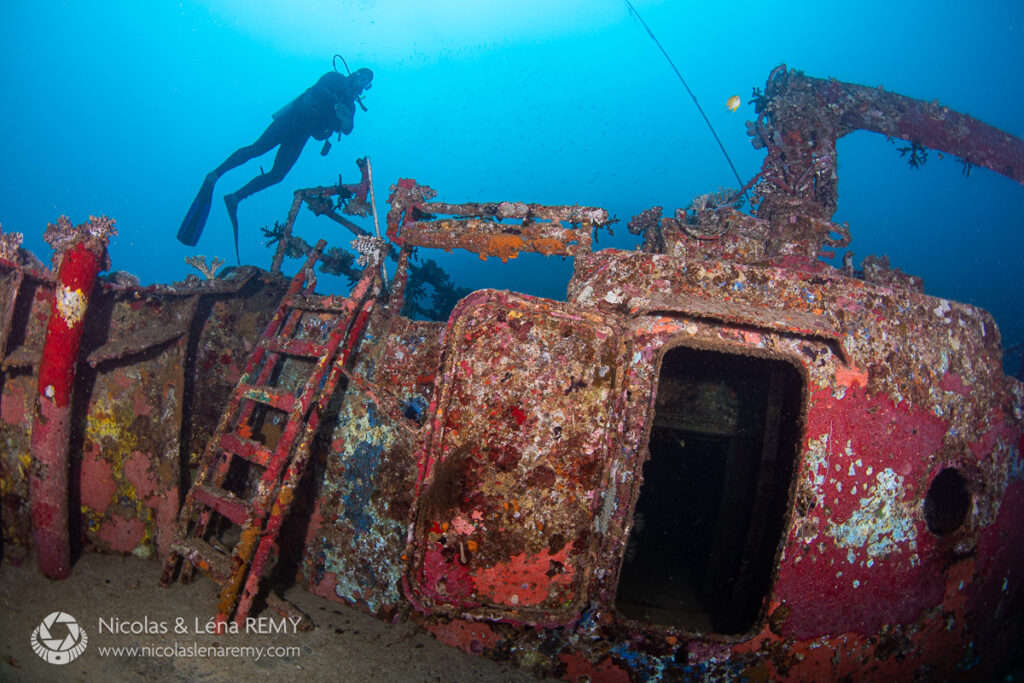 A diver swims above a rusty boat wreck in Beqa Lagoon.